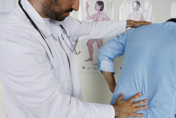 Doctor examining a patient with low back pain